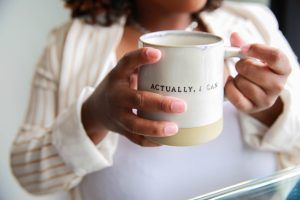 woman holding a cup saying actually I can.